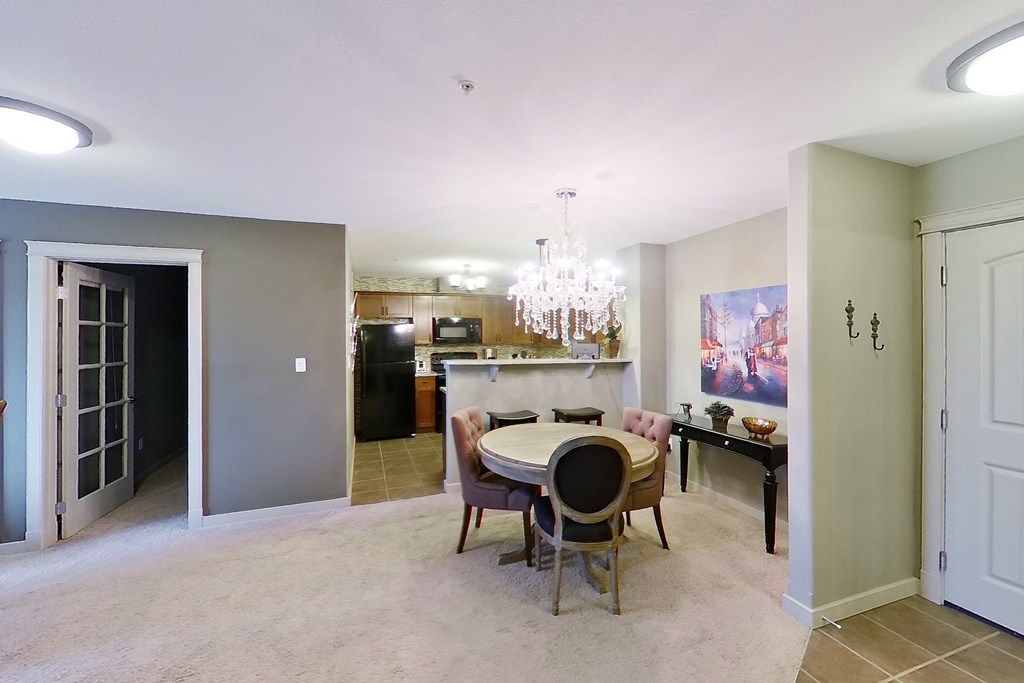 A dining room with a table set for four.
