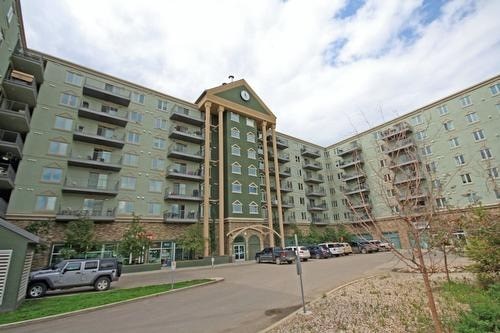A large apartment complex with a parking lot in front.