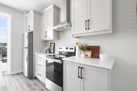 A modern kitchen with white cabinets and appliances.