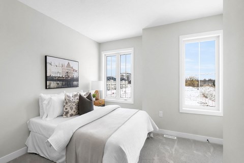 A bedroom with a large bed and a window showing a snowy landscape outside.