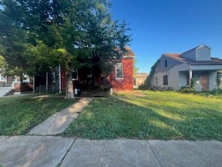 A house with a red door is surrounded by trees.