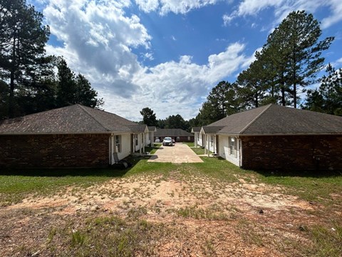 A row of houses with a dirt path between them.