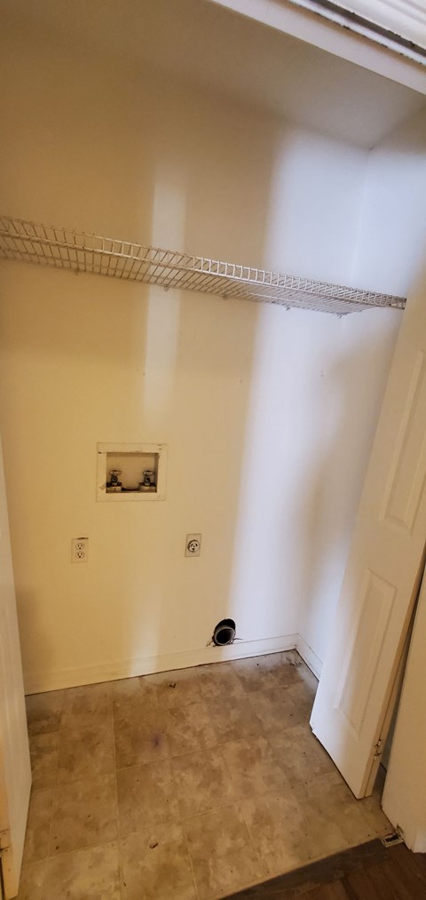 A white wall with a small picture and a white door.