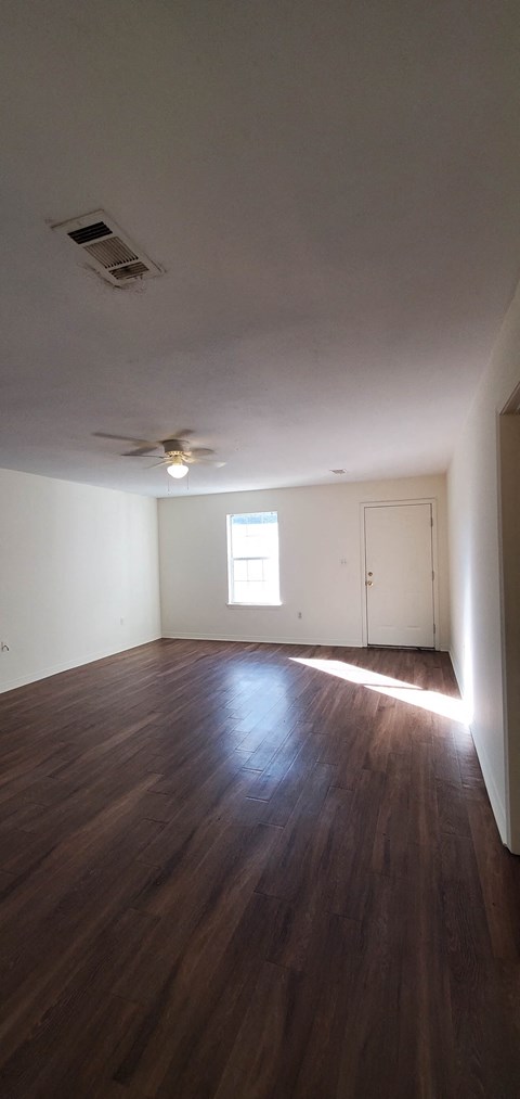 A room with wooden floors and a ceiling fan.