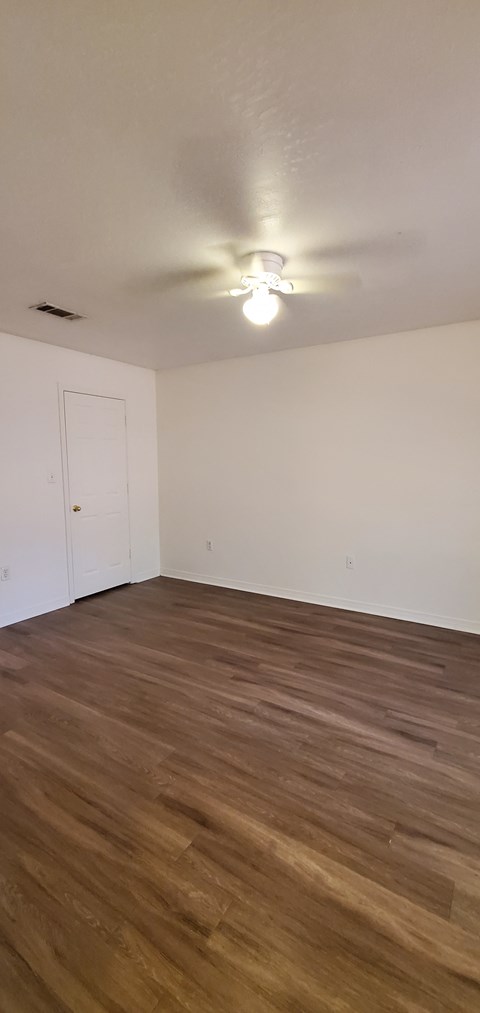A room with a white ceiling and a wooden floor.
