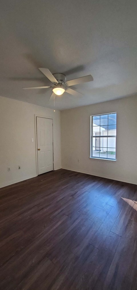 A room with a ceiling fan and a window.