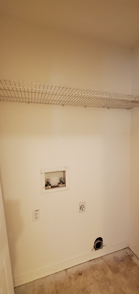 A white wall with a picture frame and two switches.