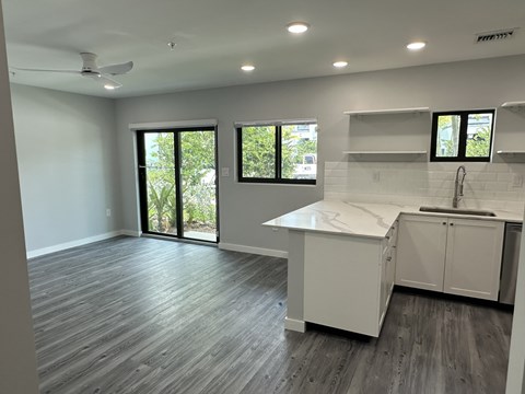 A kitchen with white cabinets and a marble countertop.