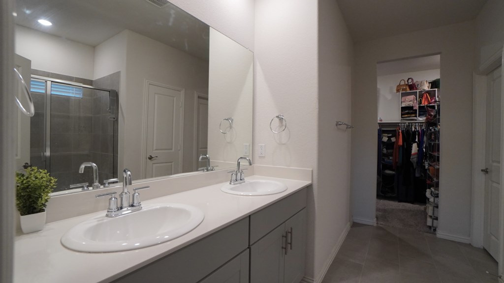 A bathroom with two sinks and a large mirror.
