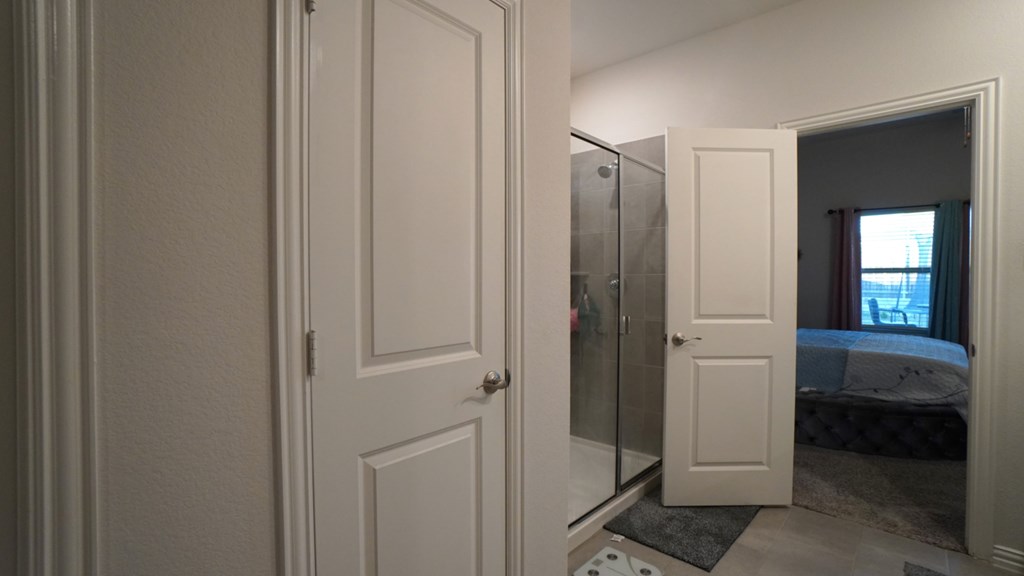 A white door is open to a bedroom.