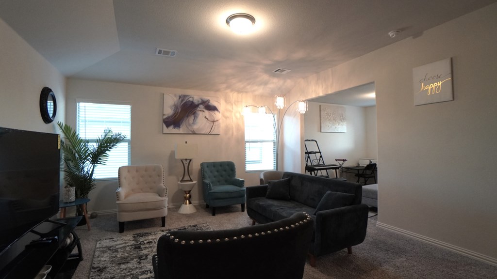 A living room with a couch, chair, and television.