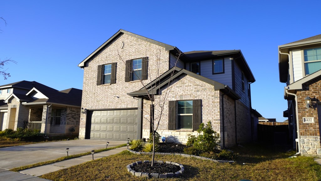 A house with a grey roof and a white garage door.