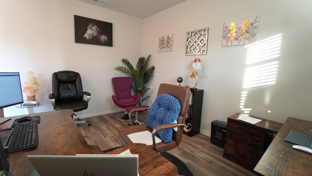 A room with a desk, chair, and computer.