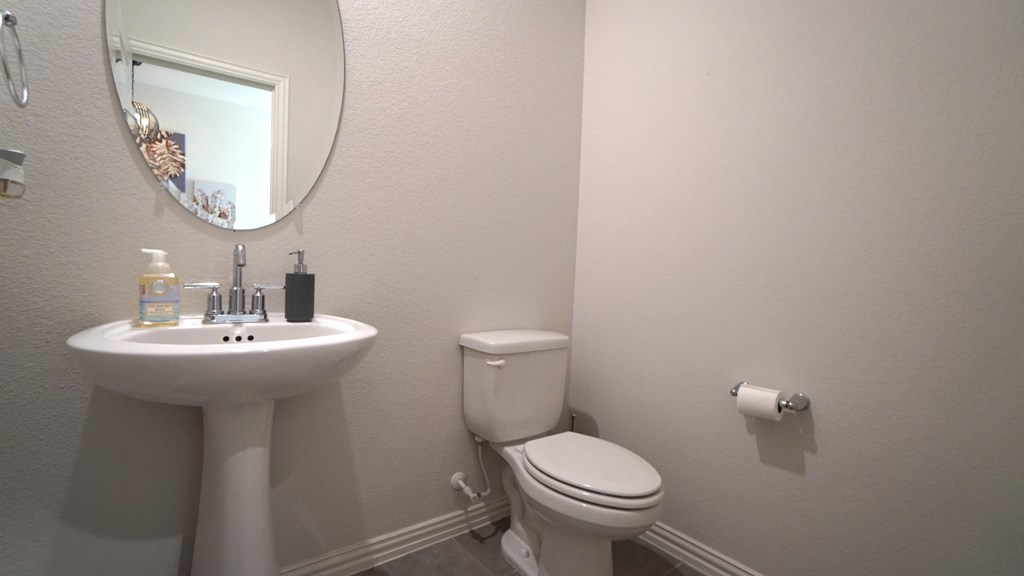 A white toilet sits next to a sink in a bathroom.