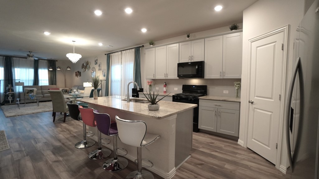 A kitchen with a white counter and a white fridge.