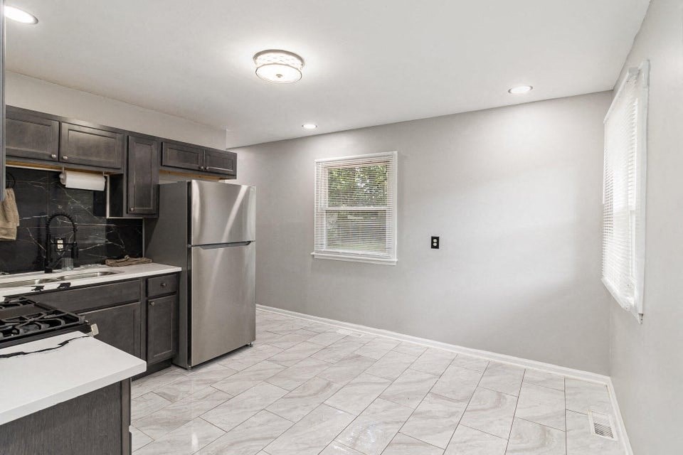 A kitchen with a stove top oven and a refrigerator.