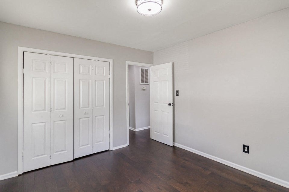 A room with two white doors and a wooden floor.