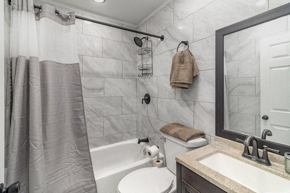 A bathroom with a white tub, sink, and towel rack.