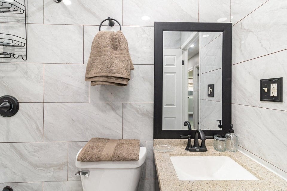 A bathroom with a white tub, sink, and towel.