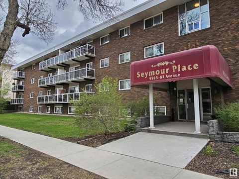Apartment building named Seymour Place with a red awning and a walkway in front.