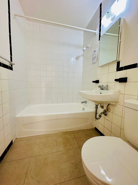 A white bathroom with a sink, toilet and bathtub.