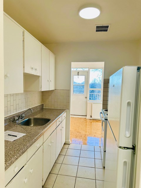 A kitchen with white cabinets and a granite counter top.
