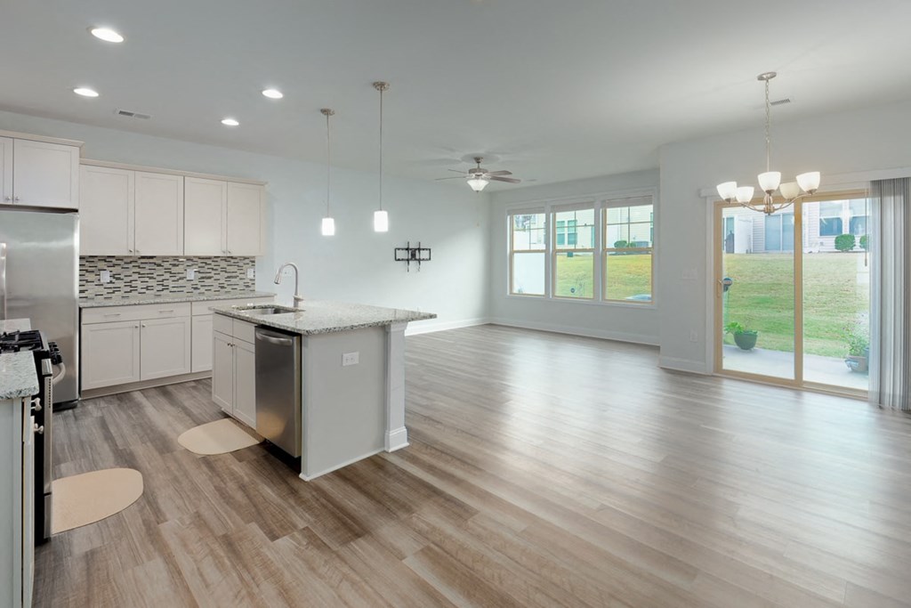 A modern kitchen with wooden floors and a large island.