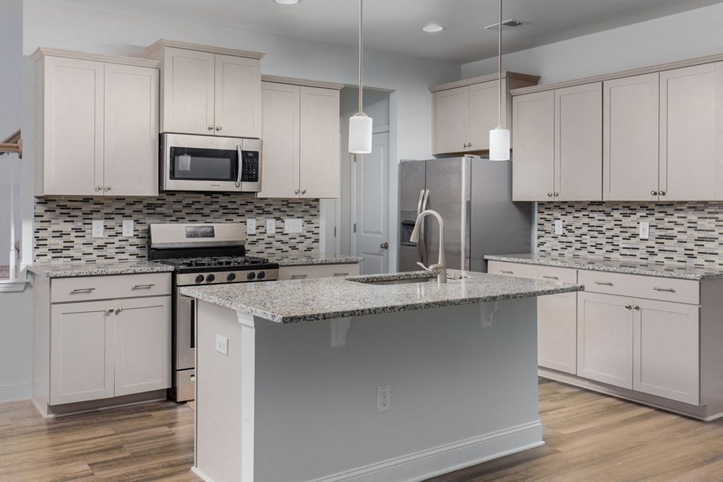A kitchen with a granite countertop and a refrigerator.