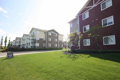 Apartment complex with a green lawn in front.