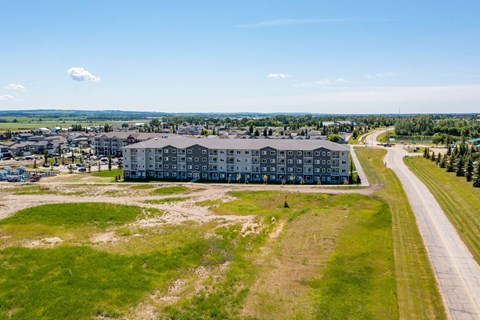 A large building complex with a parking lot in front.
