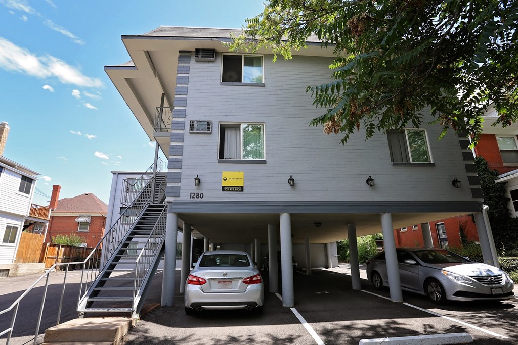 a white building with two cars parked under it
