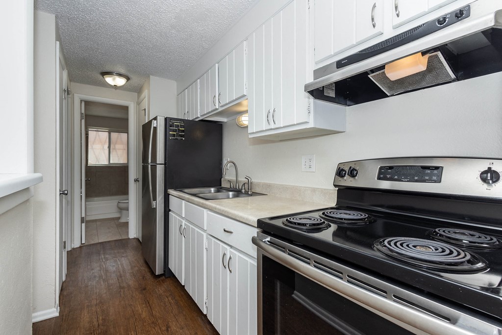 a kitchen with white cabinets and a stove and a refrigerator