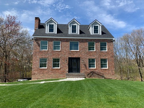 A red brick house with a black door and white trim.