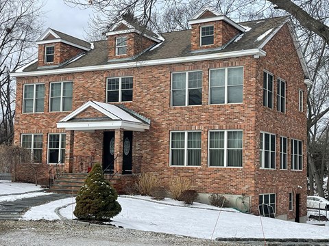 A red brick house with a black door and windows.