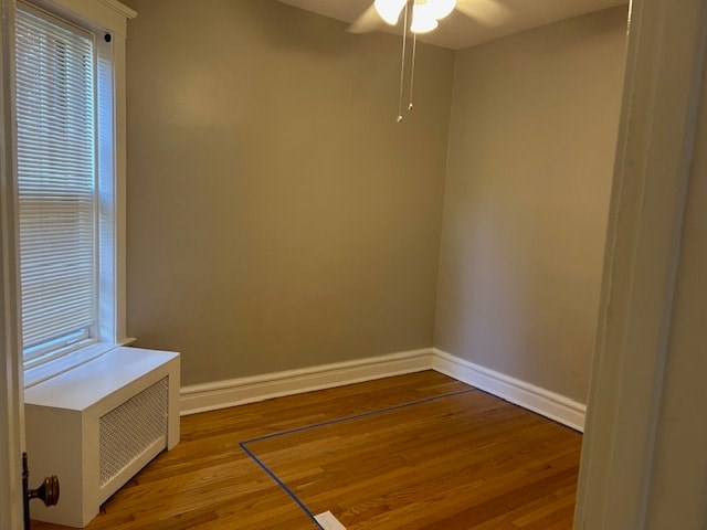 A room with a window and a white air conditioner on the floor.