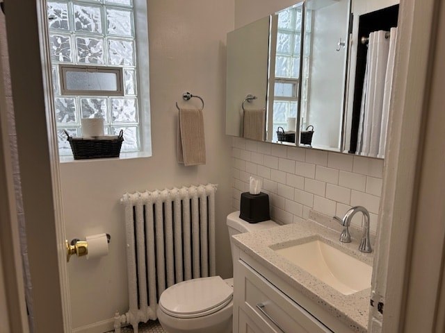 A bathroom with a toilet, sink, and a window.