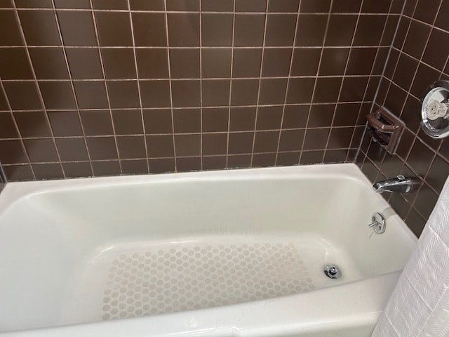 A white bathtub with a shower head and faucet.