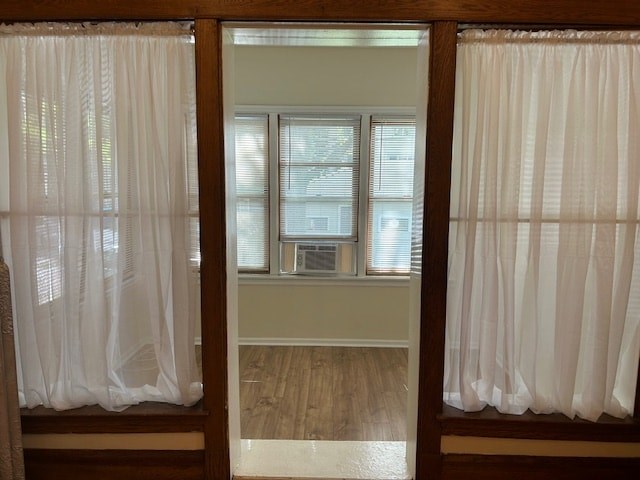 A room with a window and curtains on both sides.
