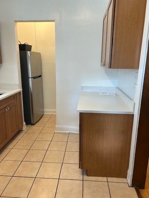 A kitchen with a black fridge and white countertops.