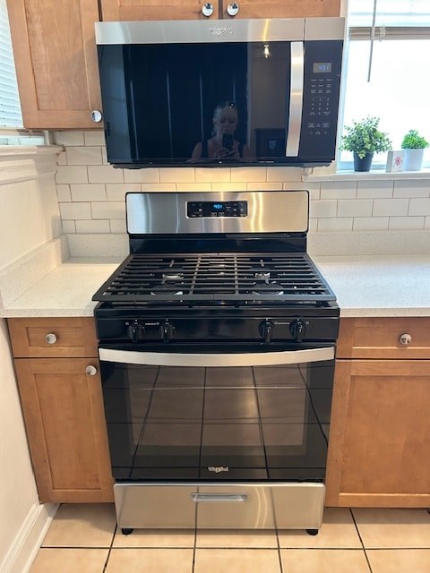 A modern kitchen with a stainless steel oven and microwave above it.