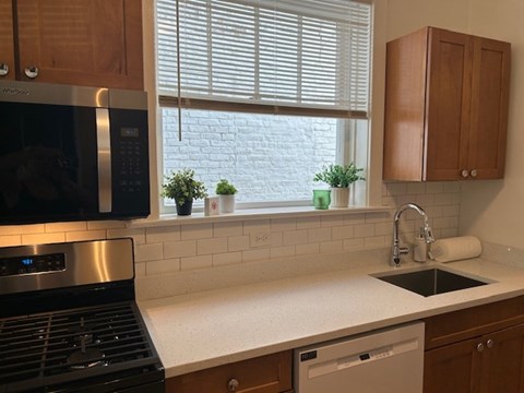 A kitchen with a black stove top oven and a white counter top.