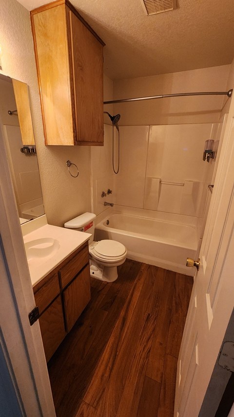 A small bathroom with a toilet, sink, and bathtub.