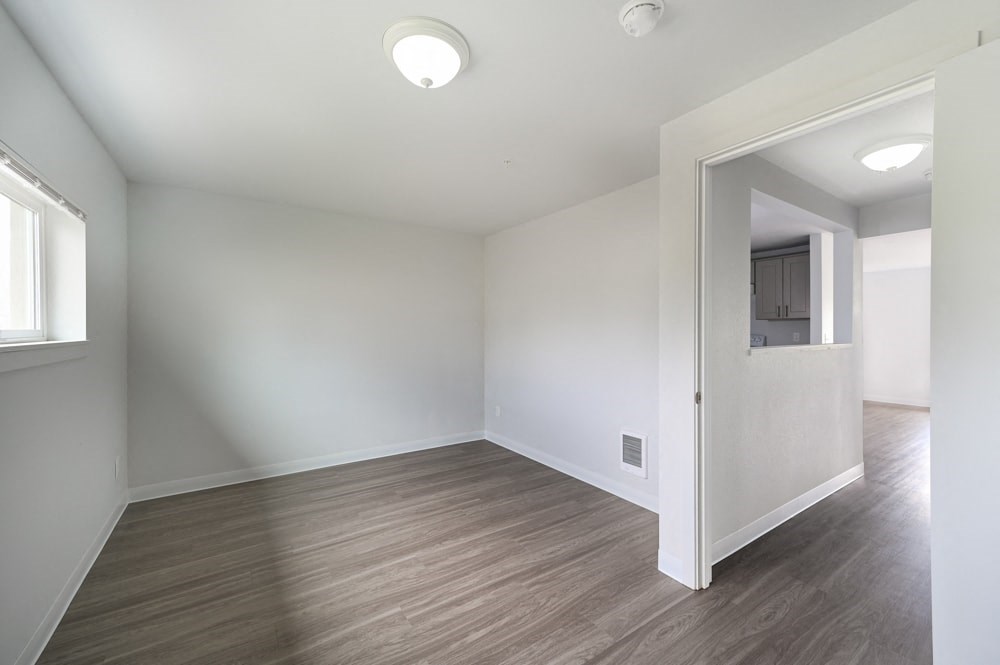 A room with a wooden floor and white walls.