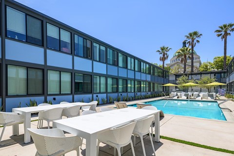 A poolside table and chairs are set up outside a building.