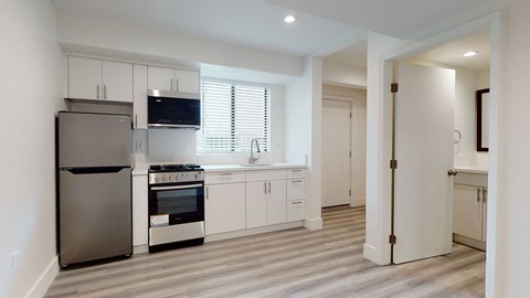 A modern kitchen with a stainless steel refrigerator and oven.
