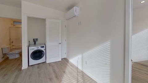 A white dryer is sitting in a laundry room.