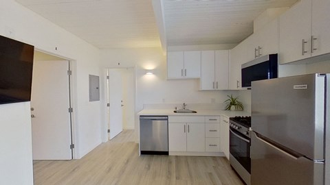 A kitchen with white cabinets and stainless steel appliances.