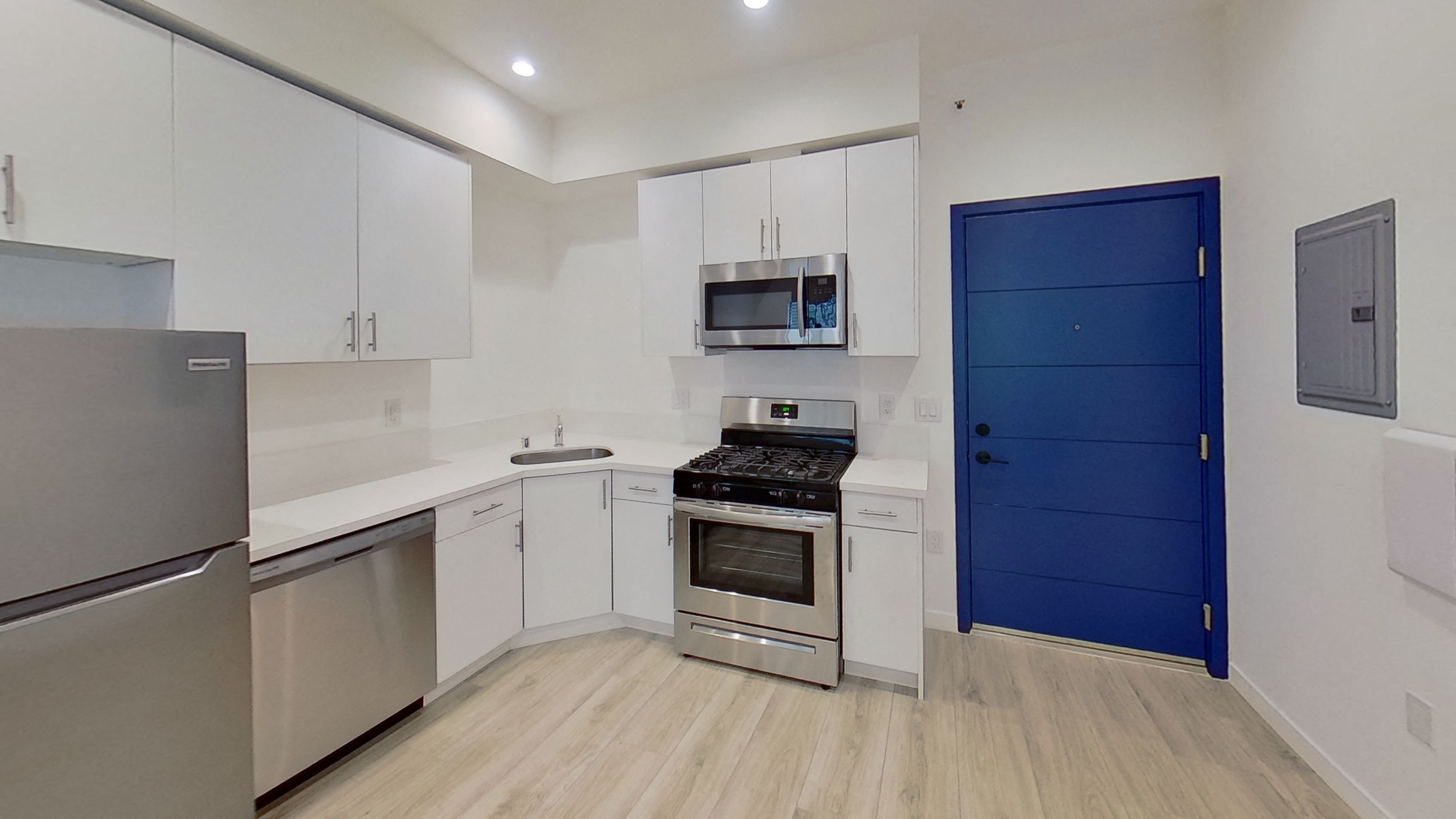 A kitchen with a blue door and stainless steel appliances.