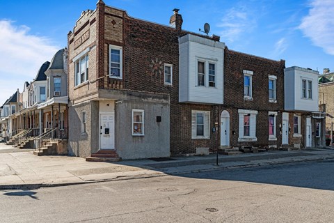 A row of old brick buildings with white trim and doors.