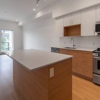 A modern kitchen with a wooden island and stainless steel appliances.